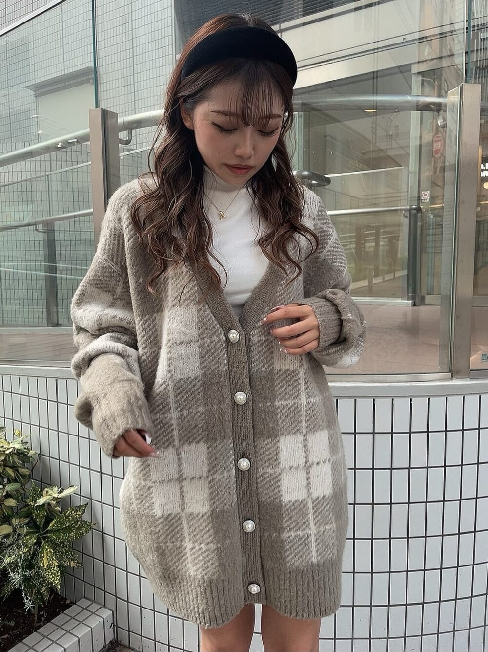 ブラック系のスカート、ホワイト系のTシャツ/カットソー、ブラック系のブーツを着用したレディースの秋コーディネートの3枚目の写真