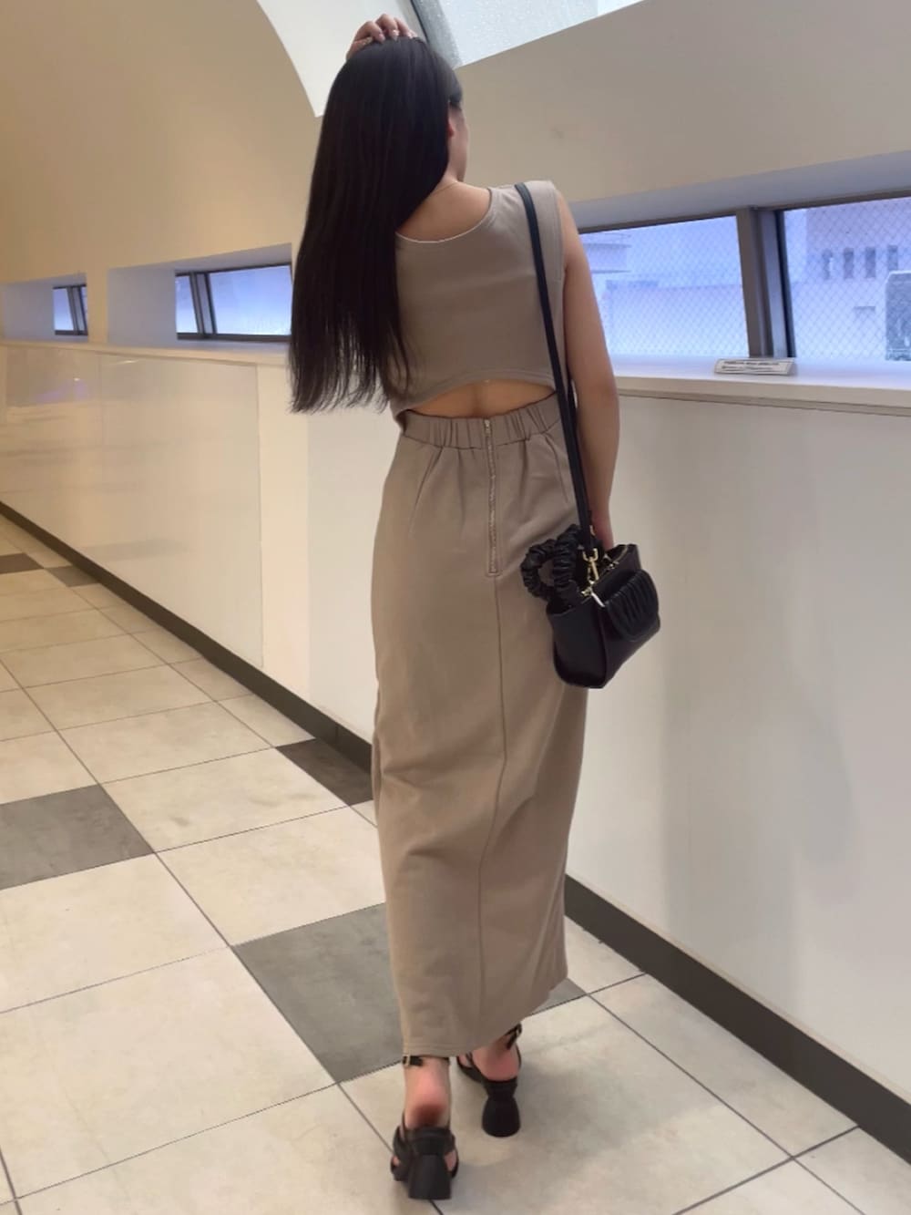 ベージュ系のワンピース、ブラック系のハンドバッグ、ブラック系のサンダルを着用したレディースの春コーディネートの3枚目の写真