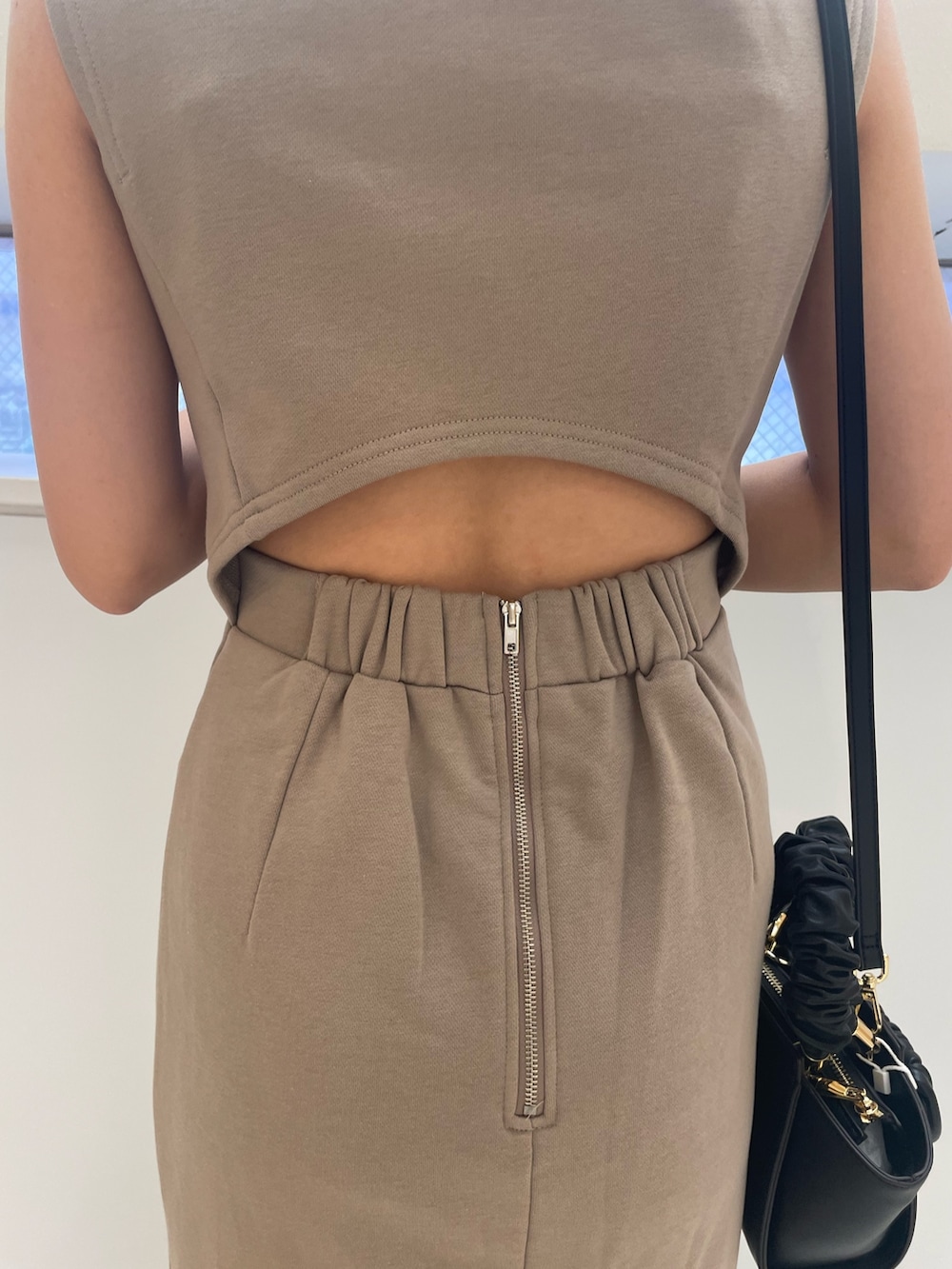 ベージュ系のワンピース、ブラック系のハンドバッグ、ブラック系のサンダルを着用したレディースの春コーディネートの5枚目の写真