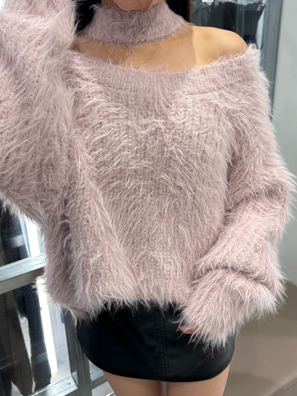 ブラック系のスカート、ピンク系のニット/セーター、ブラック系のブーツを着用したレディースの秋コーディネートの5枚目の写真