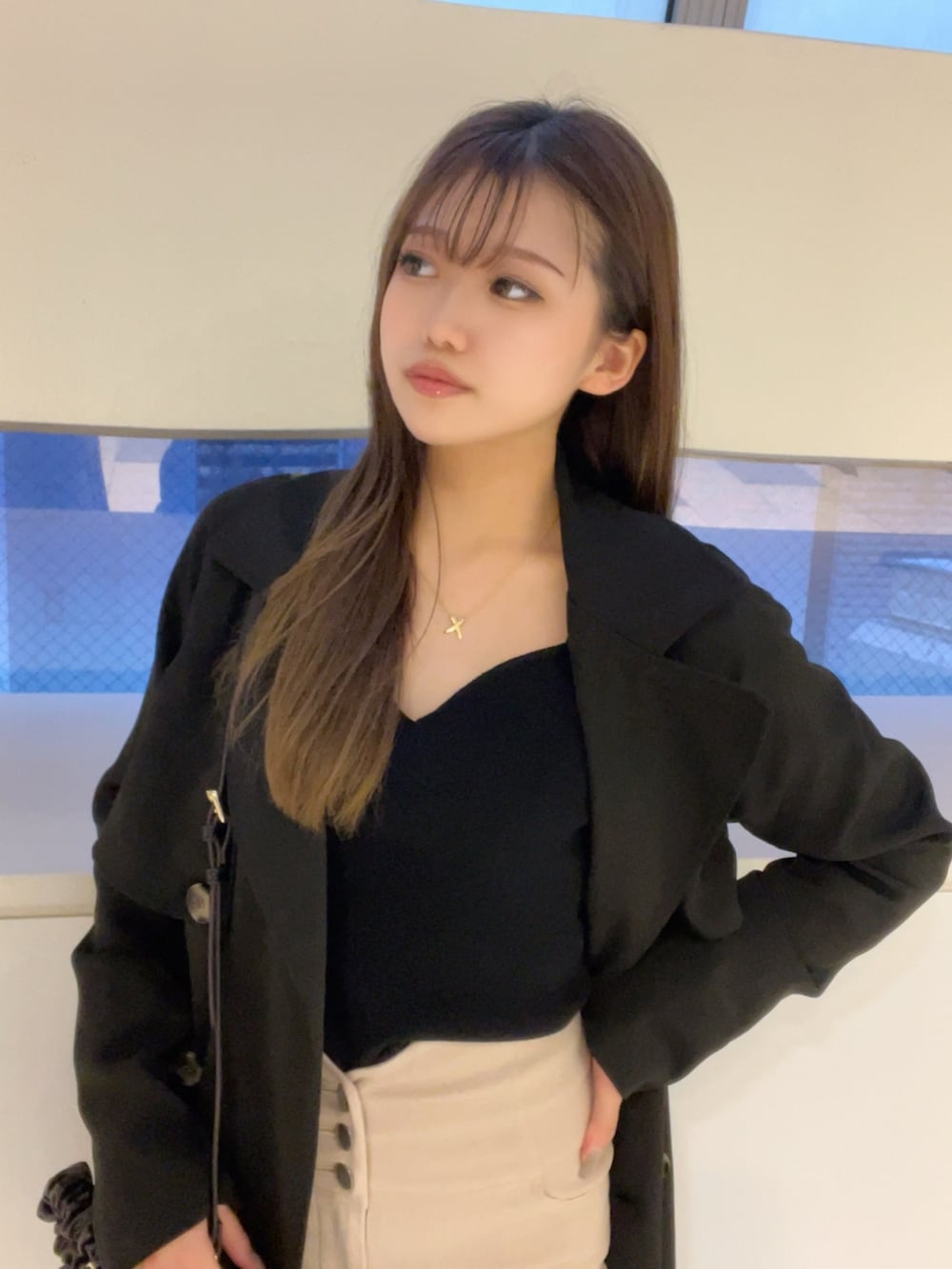 ブラック系のトレンチコート、ブラック系のニット/セーター、ブラック系のハンドバッグを着用したレディースの春コーディネートの8枚目の写真