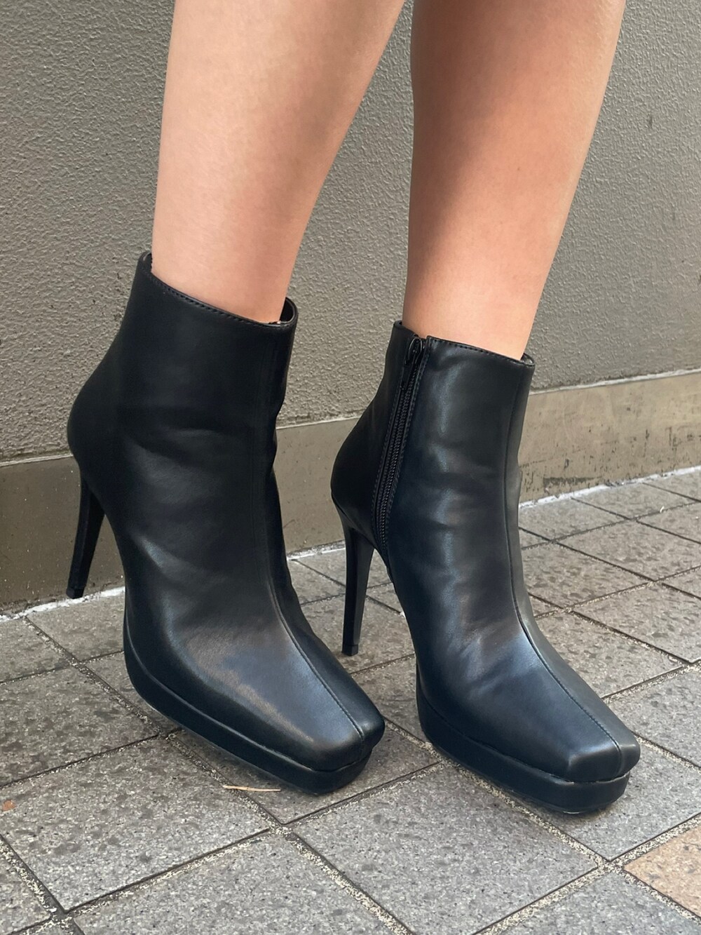 ピンク系のワンピース、ブラック系のハンドバッグ、ブラック系のブーツを着用したレディースの春コーディネートの5枚目の写真