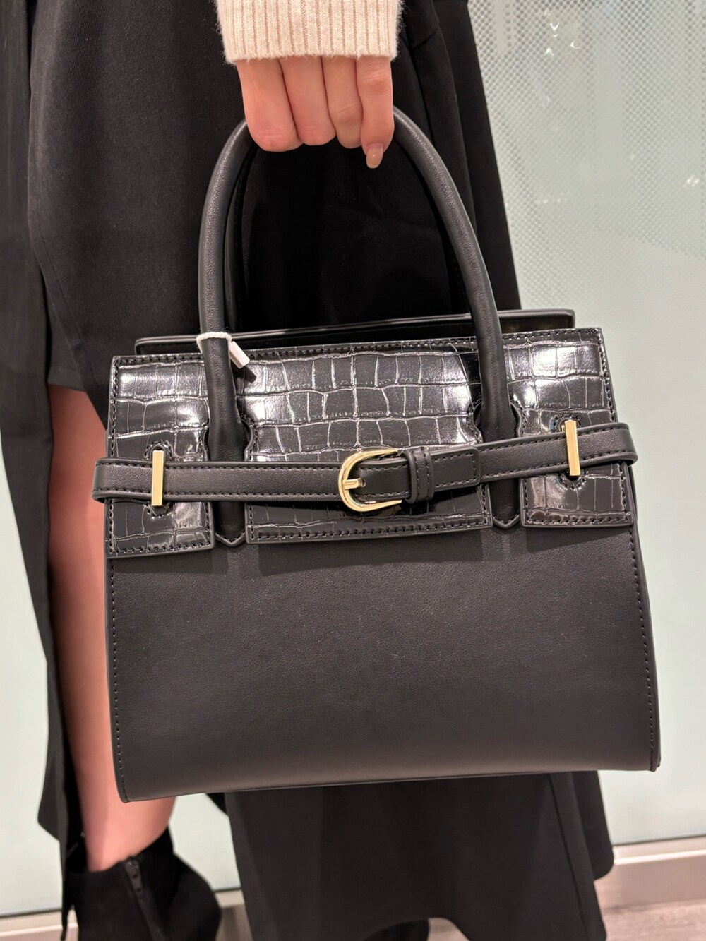 ホワイト系のニット/セーター、ブラック系のスカート、ブラック系のブーツを着用したレディースの冬コーディネートの6枚目の写真