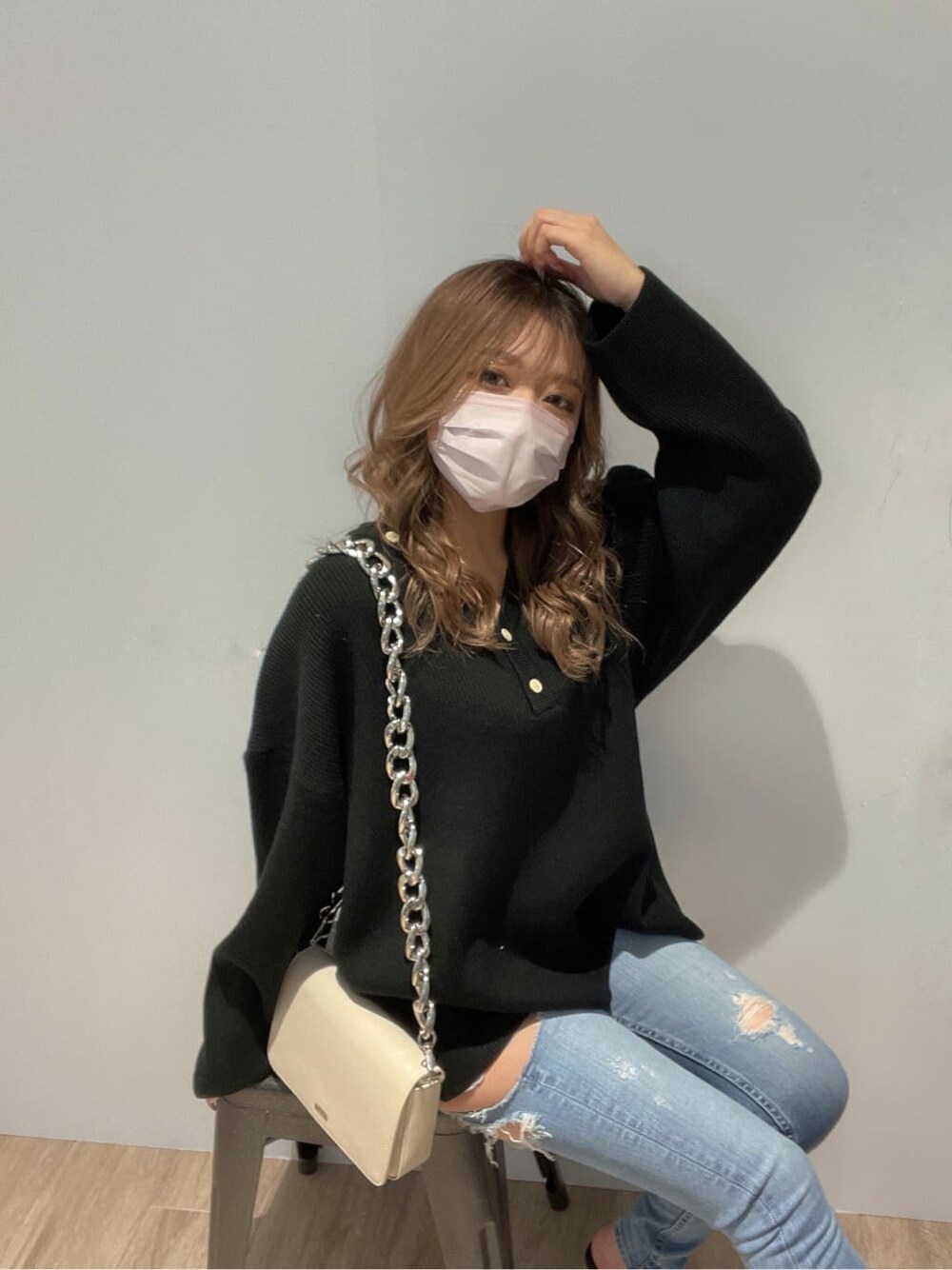 ブラック系のパンプス、ホワイト系のショルダーバッグ、ブルー系のデニムパンツを着用したレディースの冬コーディネートの2枚目の写真