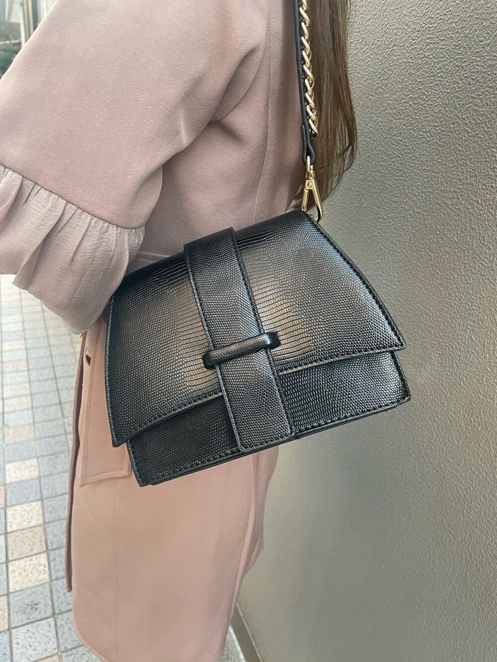 ピンク系のワンピース、ブラック系のハンドバッグ、ブラック系のブーツを着用したレディースの春コーディネートの4枚目の写真