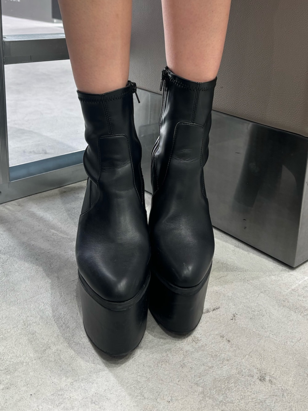 ブラック系のスカート、ピンク系のニット/セーター、ブラック系のブーツを着用したレディースの秋コーディネートの7枚目の写真