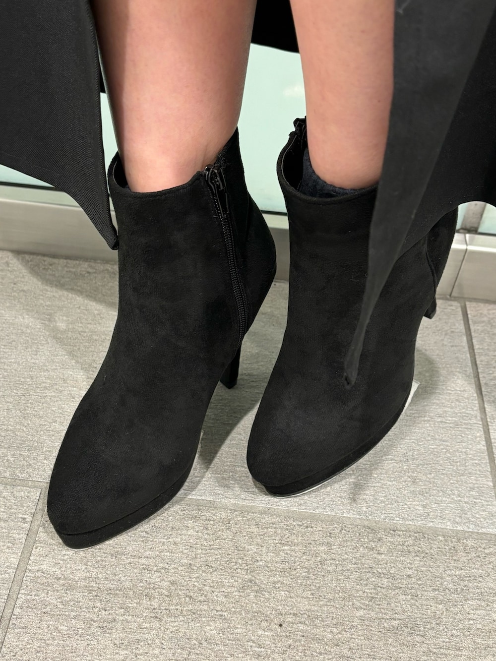 ホワイト系のニット/セーター、ブラック系のスカート、ブラック系のブーツを着用したレディースの冬コーディネートの7枚目の写真