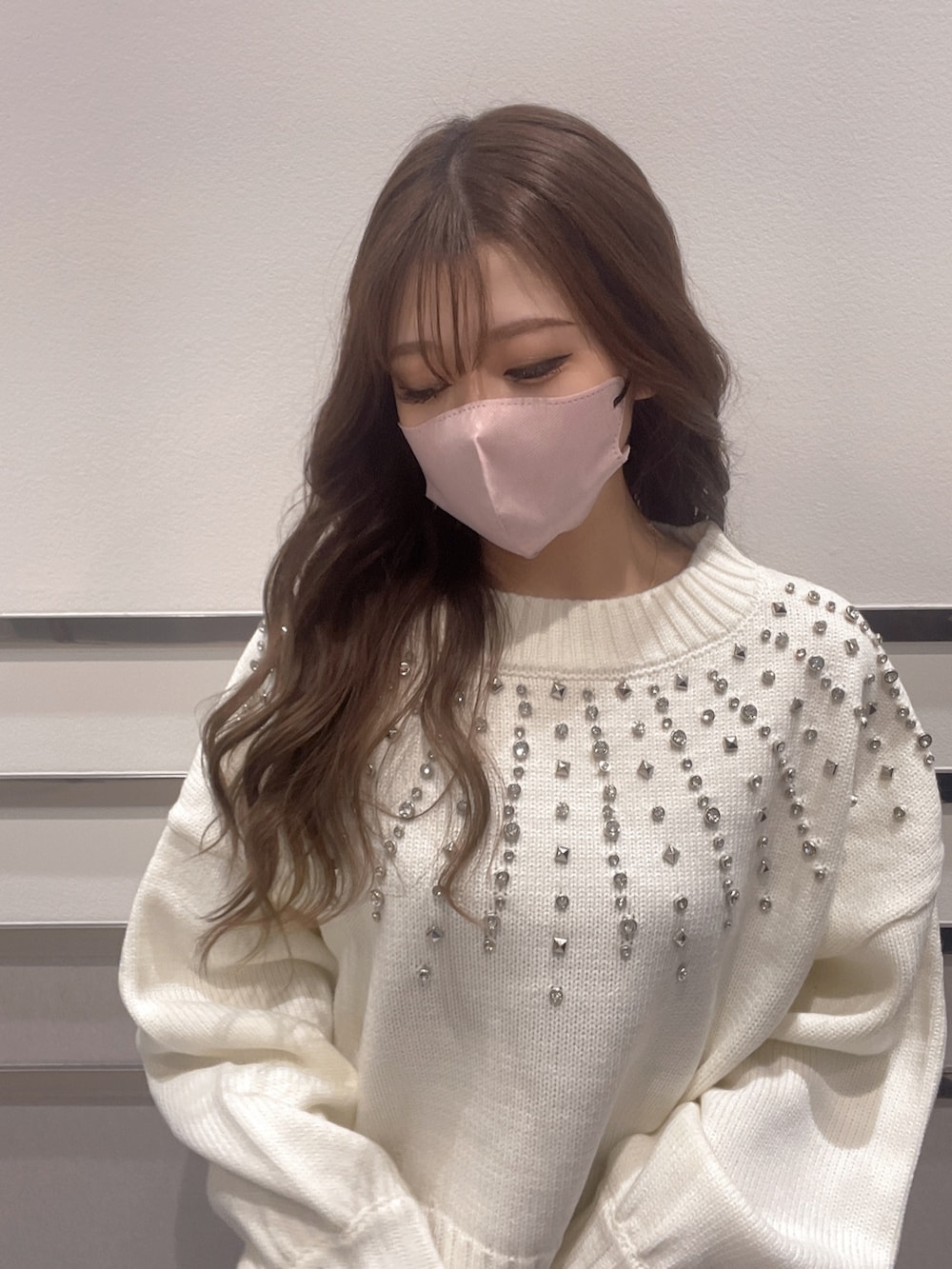 ホワイト系のニット/セーター、ブルー系のデニムパンツ、ブラック系のパンプスを着用したレディースの冬コーディネートの3枚目の写真