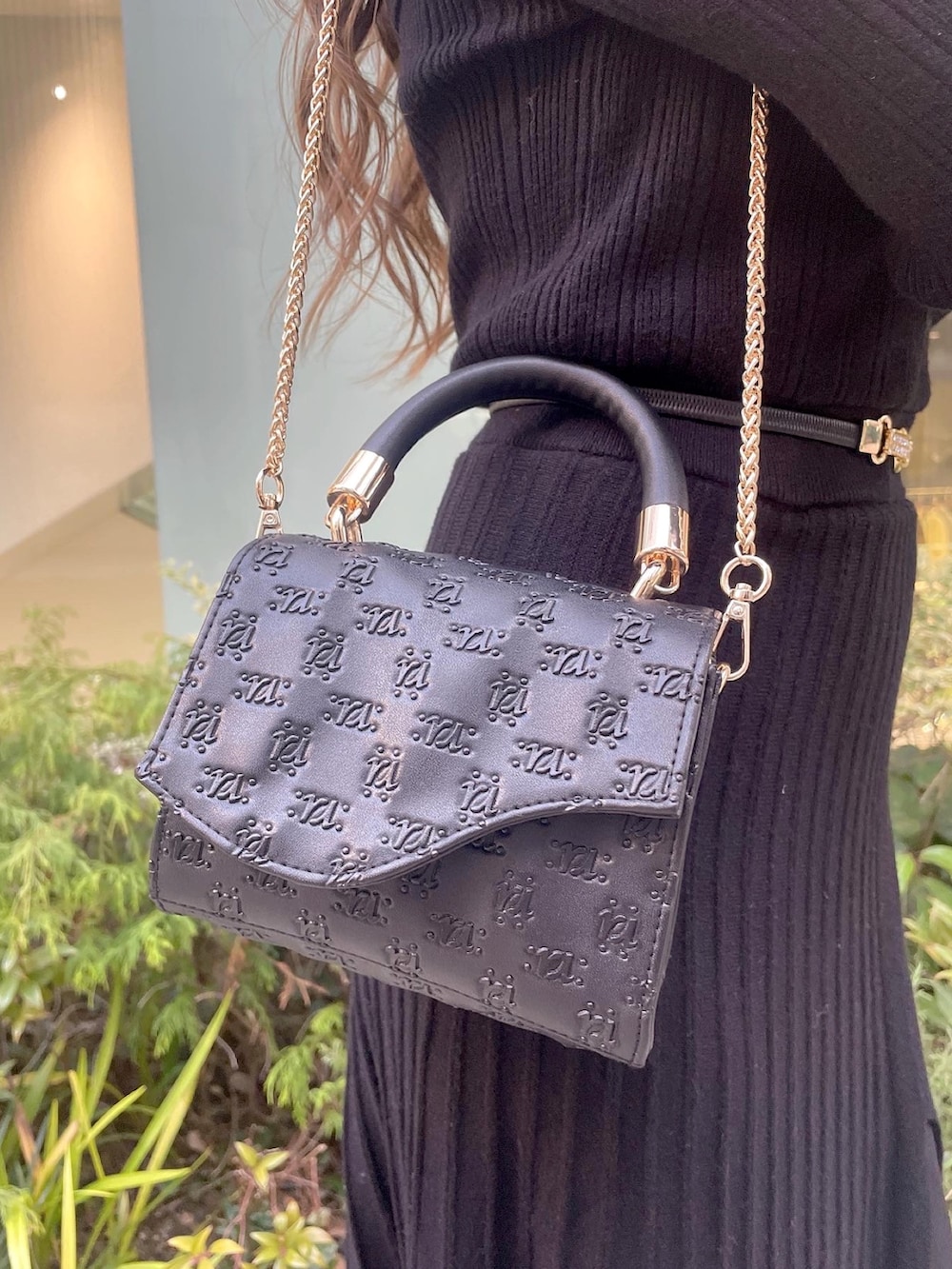 ブラック系のハンドバッグ、ブラック系のパンプス、ブラック系のワンピースを着用したレディースの冬コーディネートの3枚目の写真