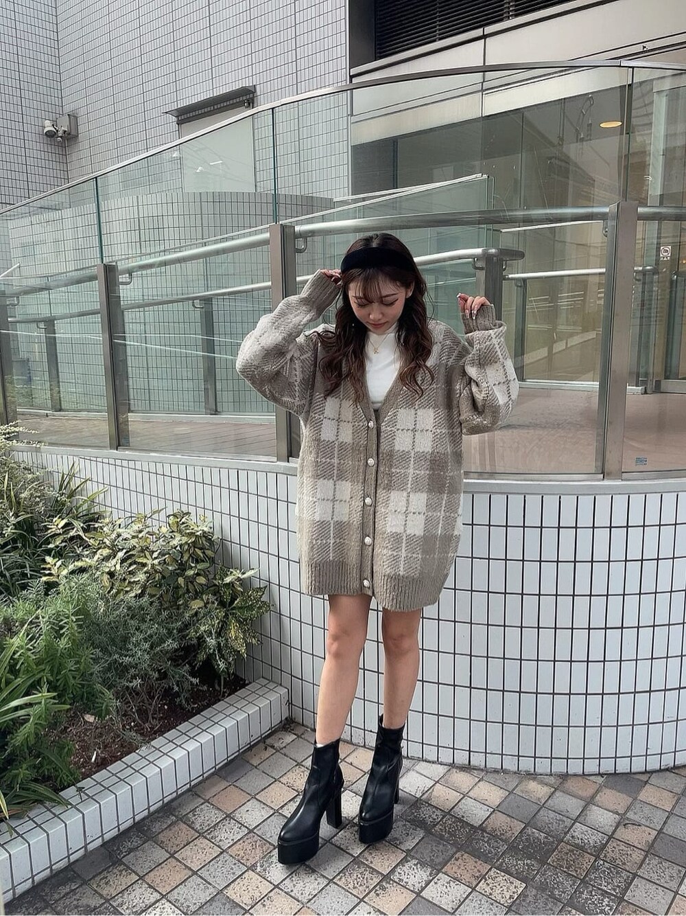 ブラック系のスカート、ホワイト系のTシャツ/カットソー、ブラック系のブーツを着用したレディースの秋コーディネートの2枚目の写真