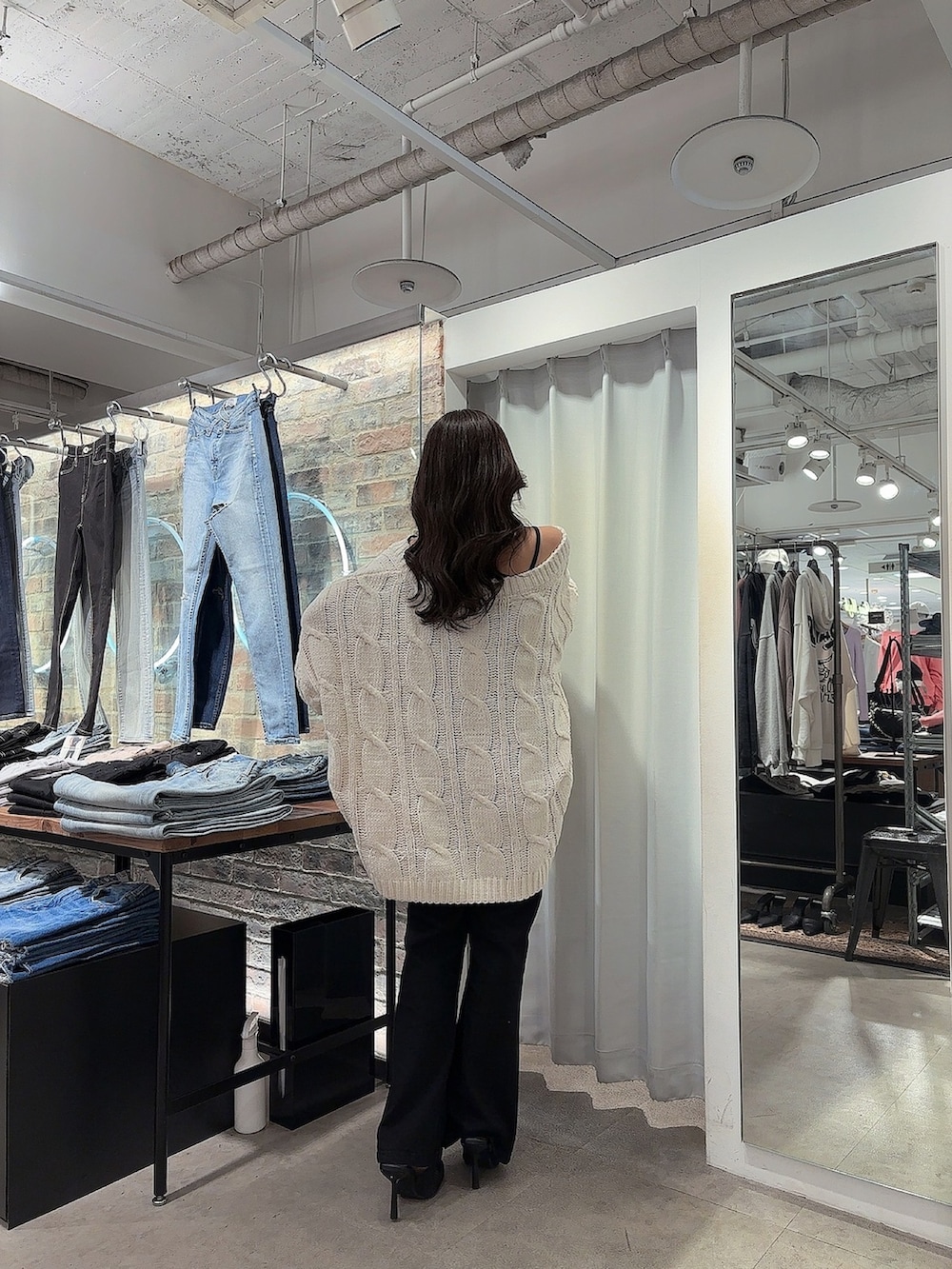 ブラック系のパンプス、ブラック系のサロペット/オーバーオール、ホワイト系のカーディガン/ボレロを着用したレディースの春コーディネートの2枚目の写真