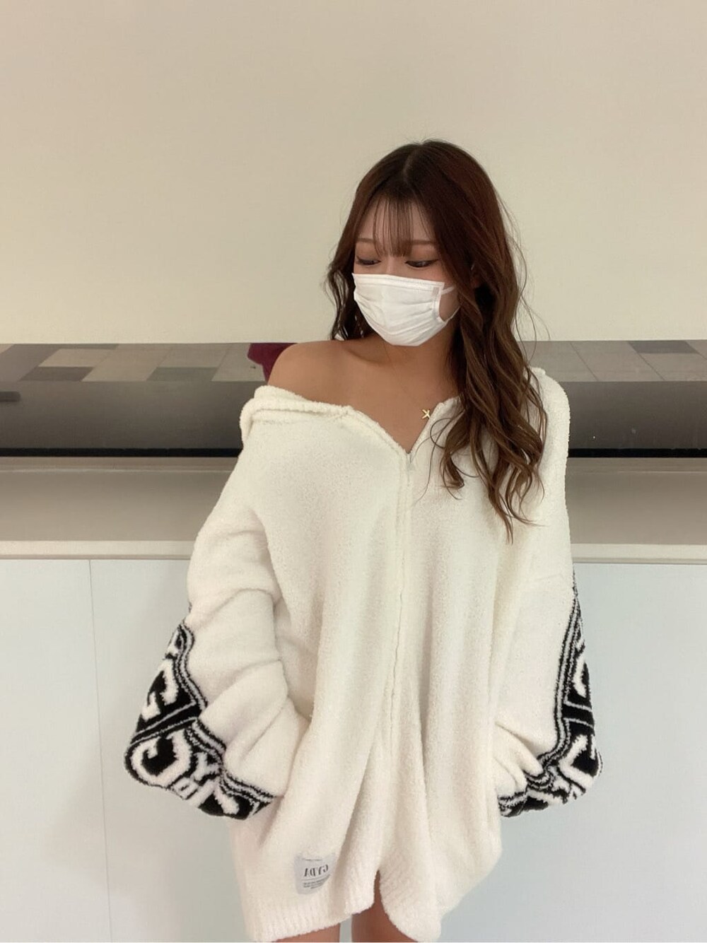 ブラック系のブーツ、ブラック系のスカート、ホワイト系のカーディガン/ボレロを着用したレディースの秋コーディネートの4枚目の写真