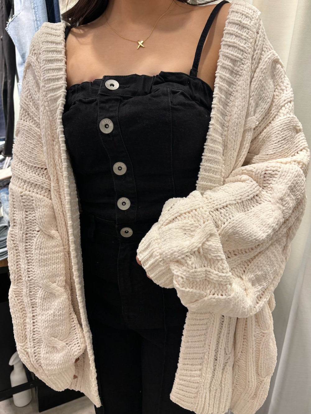 ブラック系のパンプス、ブラック系のサロペット/オーバーオール、ホワイト系のカーディガン/ボレロを着用したレディースの春コーディネートの3枚目の写真