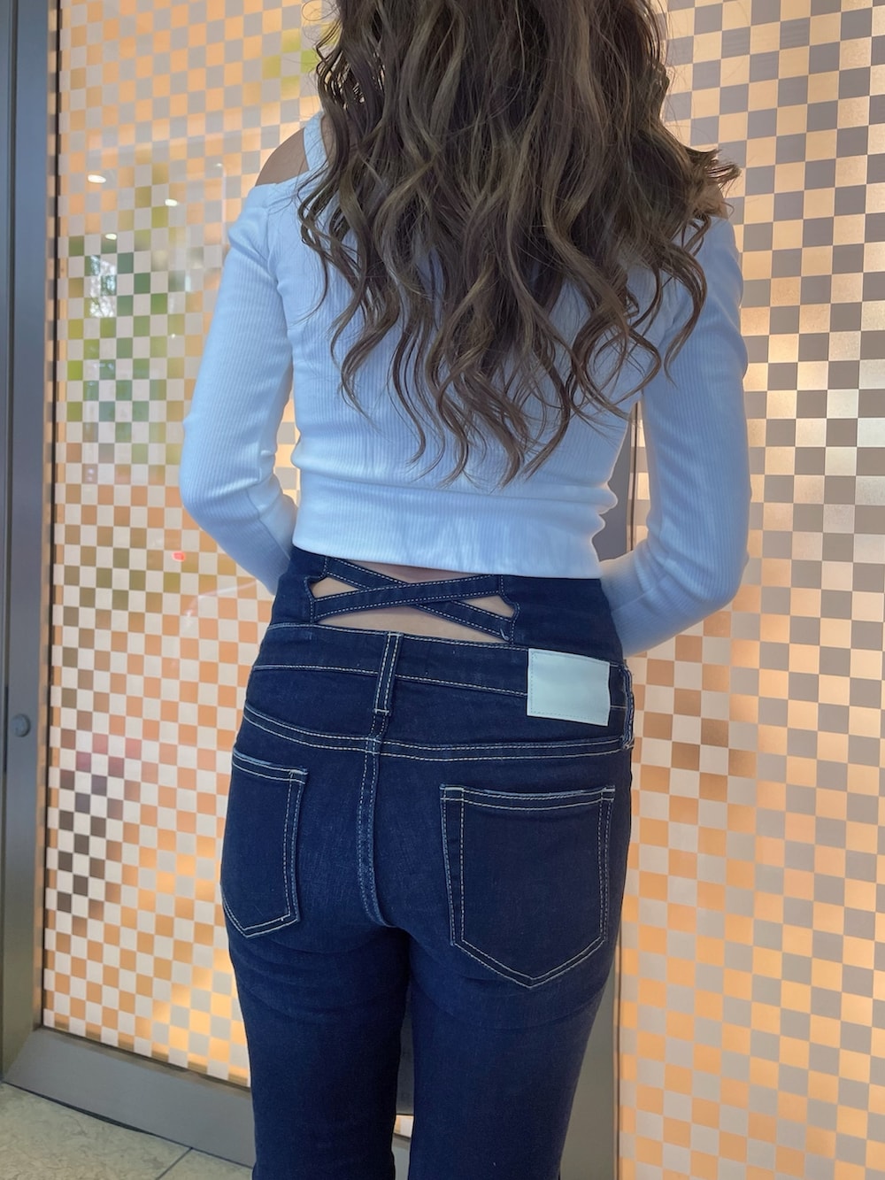 グレー系のライダースジャケット、ホワイト系のTシャツ/カットソー、ブルー系のデニムパンツを着用したレディースの冬コーディネートの5枚目の写真