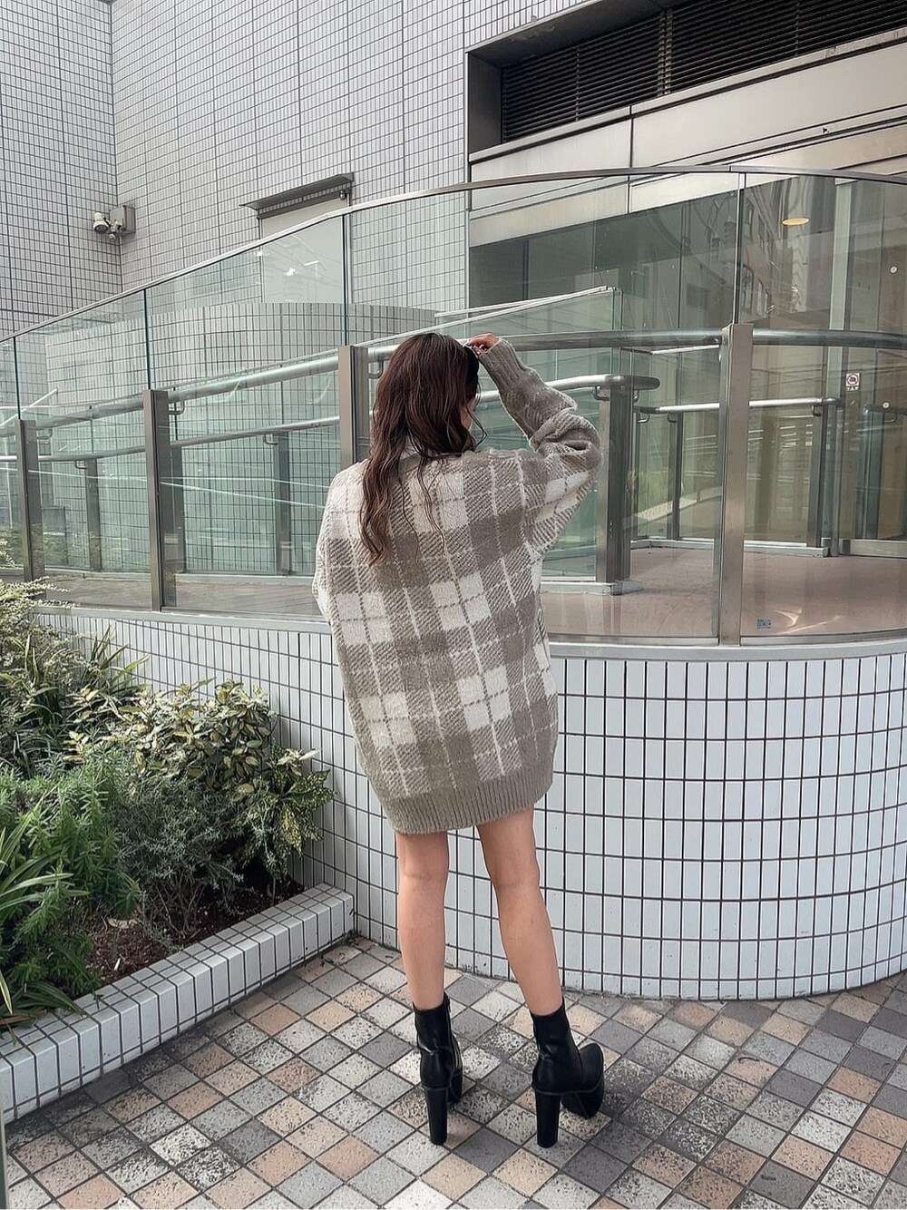 ブラック系のスカート、ホワイト系のTシャツ/カットソー、ブラック系のブーツを着用したレディースの秋コーディネートの4枚目の写真