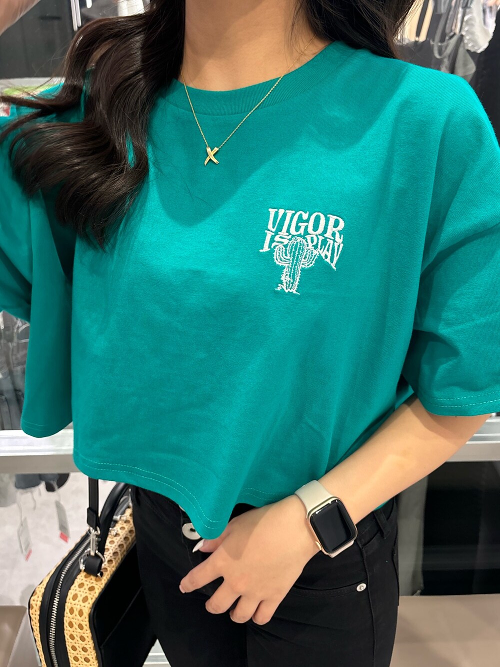 ホワイト系のサンダル、ブラック系のデニムパンツ、グリーン系のTシャツ/カットソーを着用したレディースの夏コーディネートの4枚目の写真