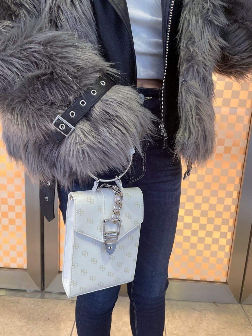 グレー系のライダースジャケット、ホワイト系のTシャツ/カットソー、ブルー系のデニムパンツを着用したレディースの冬コーディネートの4枚目の写真