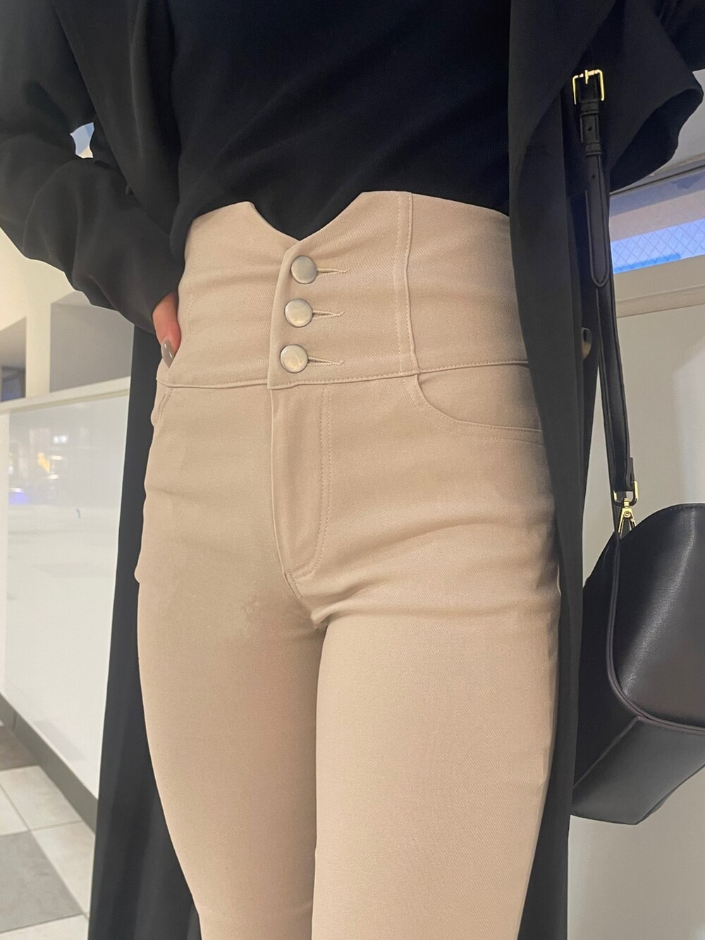 ブラック系のトレンチコート、ブラック系のニット/セーター、ブラック系のハンドバッグを着用したレディースの春コーディネートの7枚目の写真