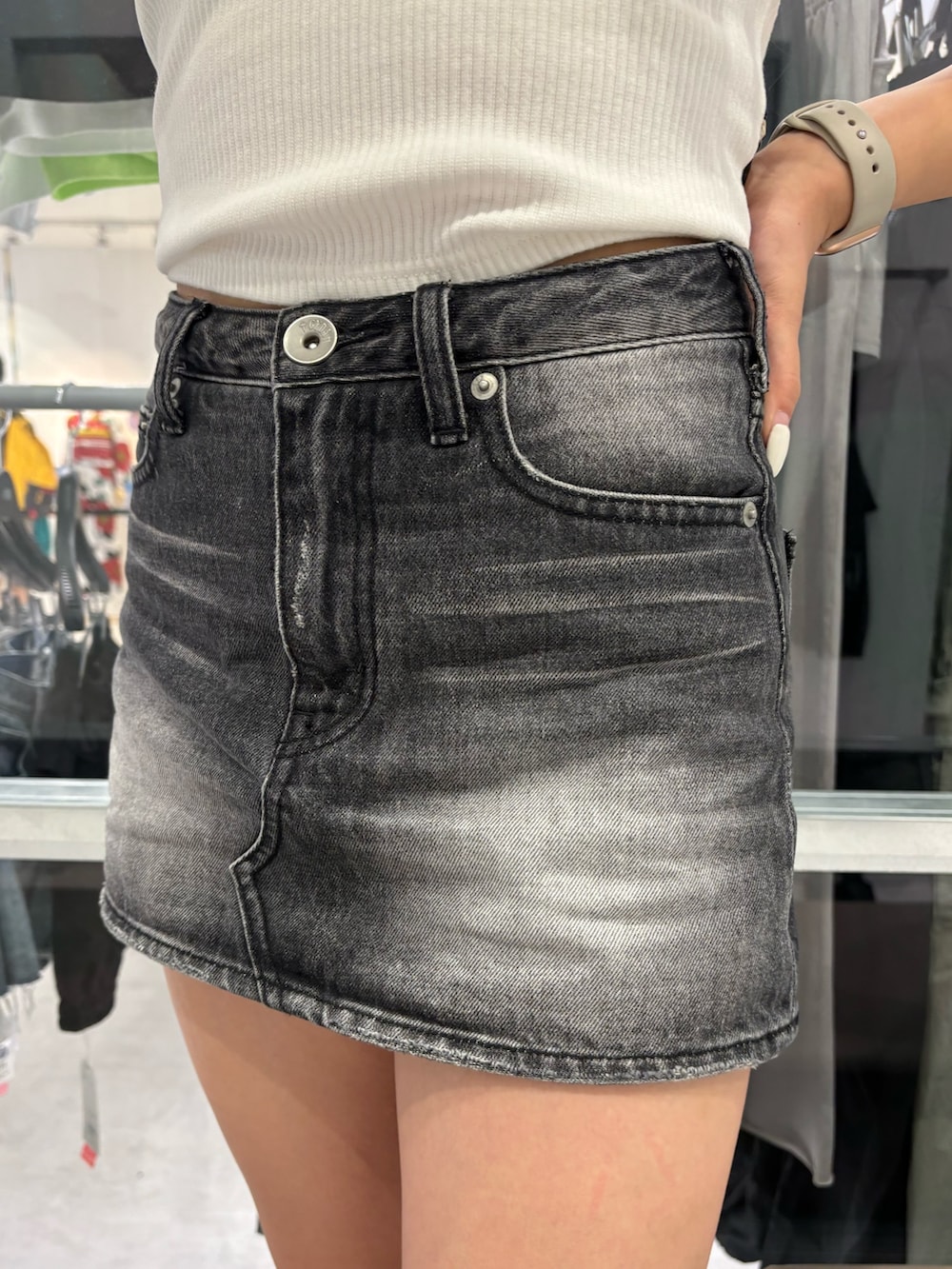 ブラック系のサンダル、ホワイト系のTシャツ/カットソー、ブラック系のデニムスカートを着用したレディースの夏コーディネートの6枚目の写真