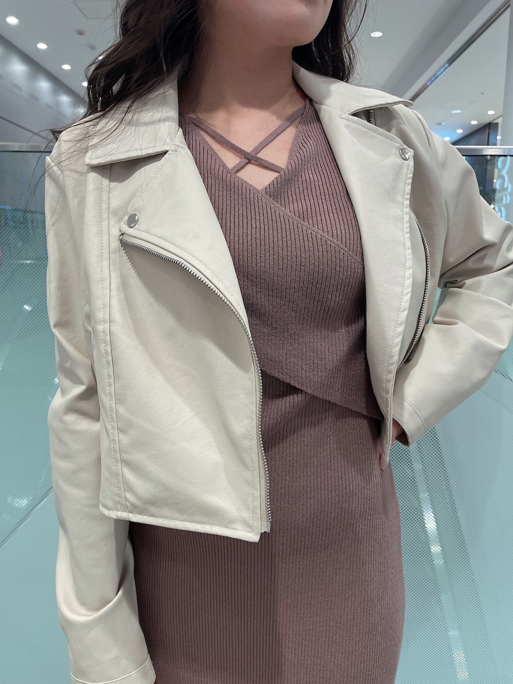 ブラック系のワンピース、ホワイト系のライダースジャケット、ホワイト系のパンプスを着用したレディースの冬コーディネートの4枚目の写真