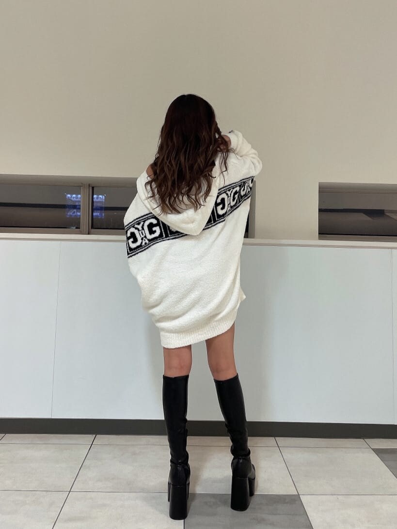 ブラック系のブーツ、ブラック系のスカート、ホワイト系のカーディガン/ボレロを着用したレディースの秋コーディネートの5枚目の写真