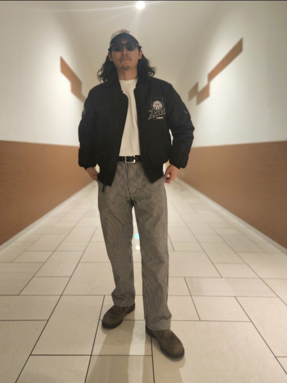 ブラック系のMA-1、その他のチノパンツ、ホワイト系のTシャツ/カットソーを着用したメンズの冬コーディネートの3枚目の写真