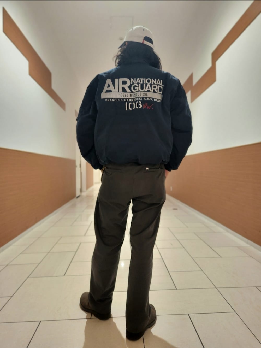 ホワイト系のTシャツ/カットソー、グレー系のチノパンツ、ホワイト系のキャップを着用したメンズの秋コーディネートの2枚目の写真