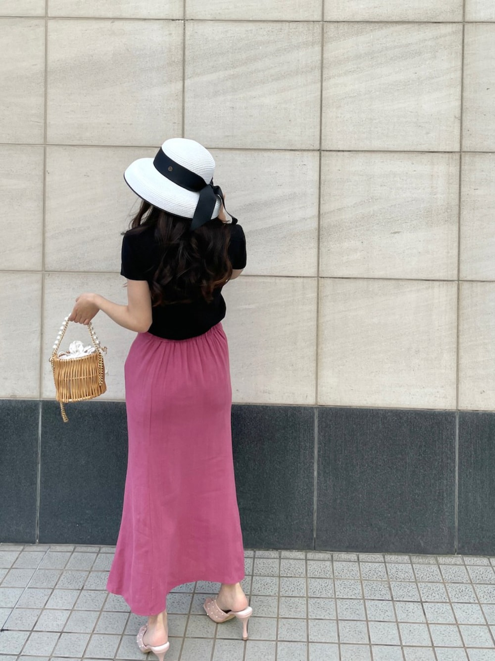 ピンク系のサンダル、ピンク系のスカート、ブラック系のTシャツ/カットソーを着用したレディースの夏コーディネートの2枚目の写真