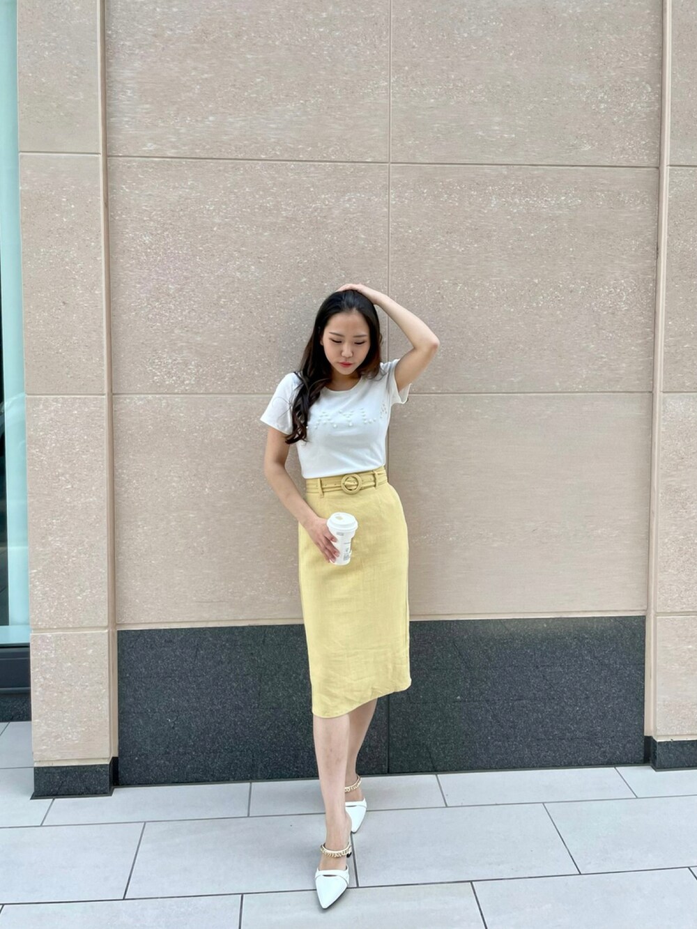 ホワイト系のTシャツ/カットソー、イエロー系のスカート、ホワイト系のサンダルを着用したレディースの春コーディネートの2枚目の写真