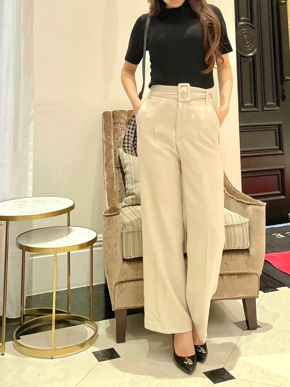 ブラック系のニット/セーター、ベージュ系のその他パンツ、ブラック系のパンプスを着用したレディースの秋コーディネートの2枚目の写真