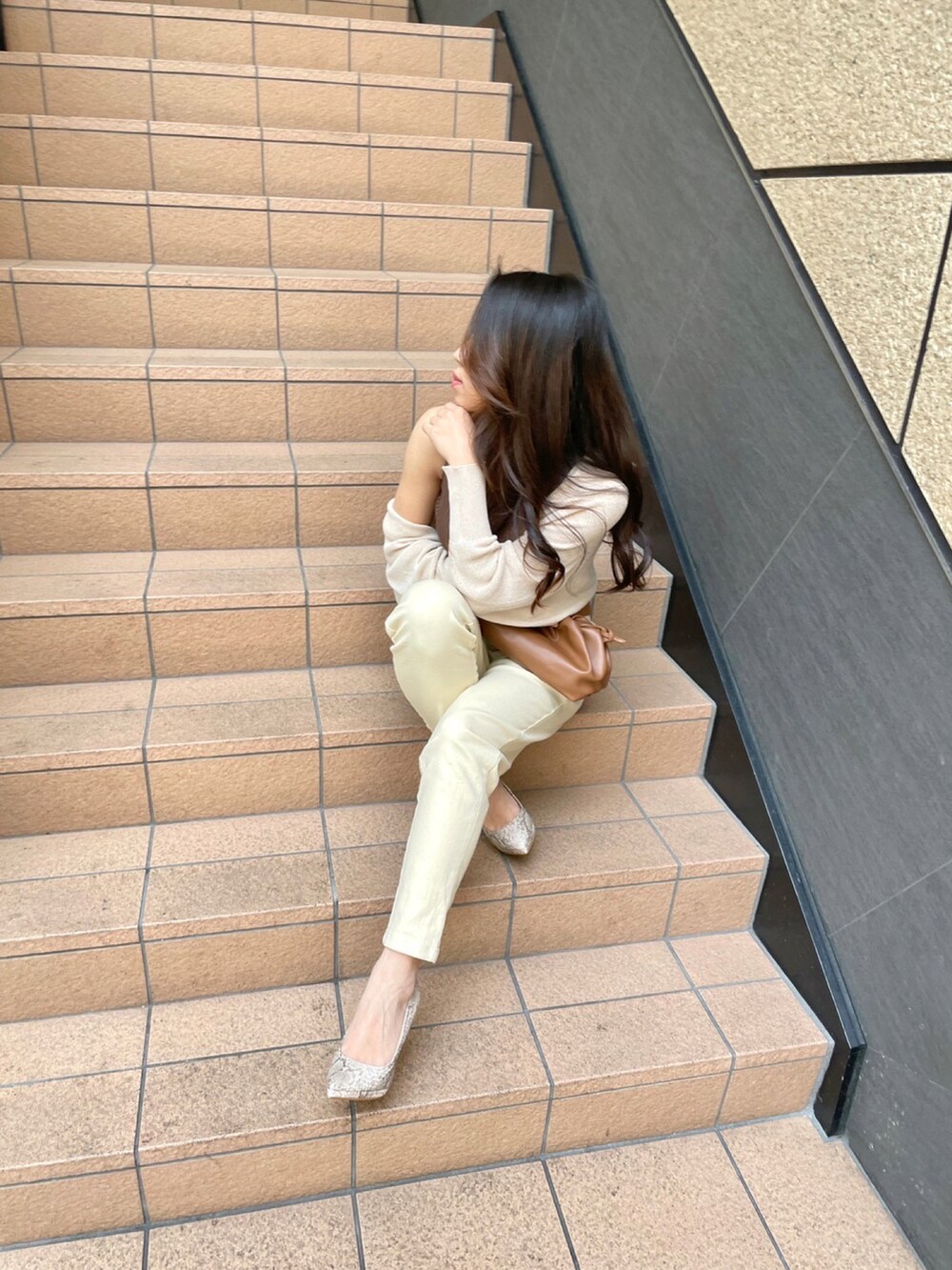 ホワイト系のカーディガン/ボレロ、ブラウン系のニット/セーター、ベージュ系のその他パンツを着用したレディースの春コーディネートの2枚目の写真