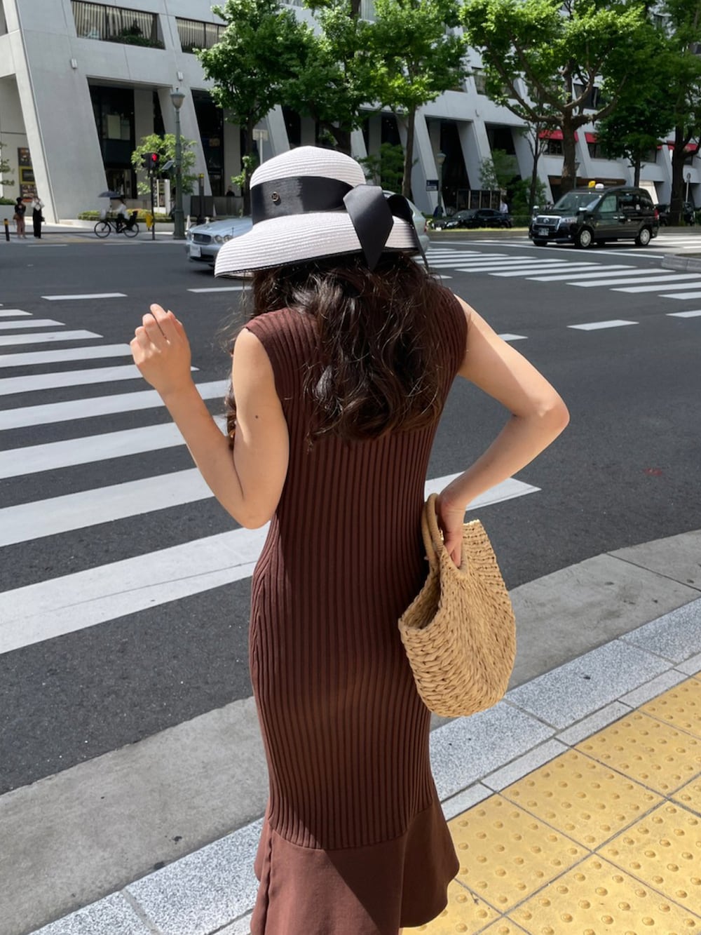 ブラウン系のワンピース、ブラウン系のサンダル、ベージュ系のかごバッグを着用したレディースの夏コーディネートの3枚目の写真