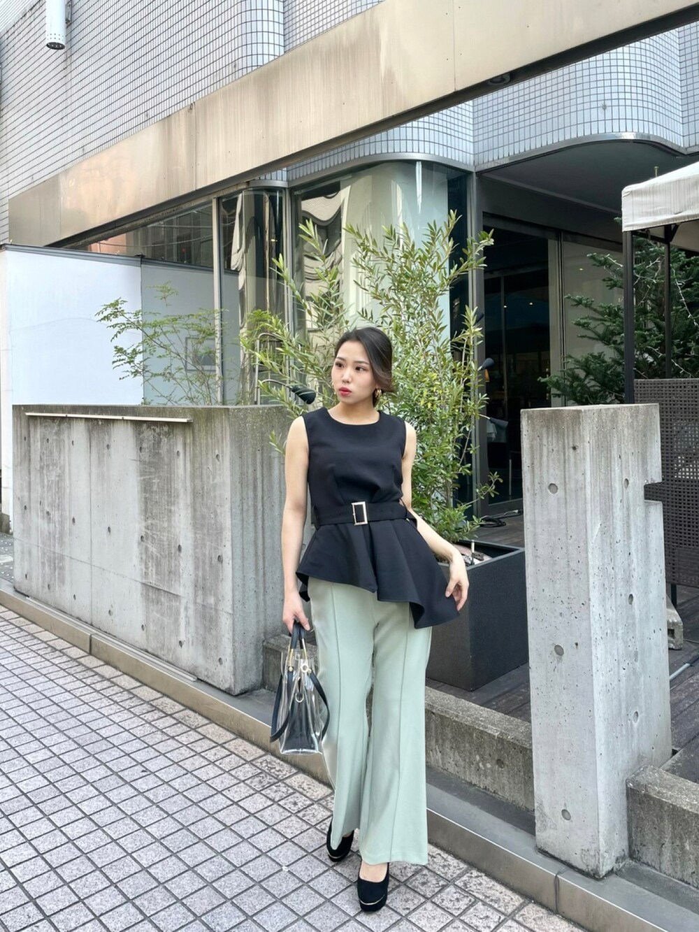 ブラック系のハンドバッグ、ブラック系のTシャツ/カットソー、グリーン系のその他パンツを着用したレディースの春コーディネートの2枚目の写真