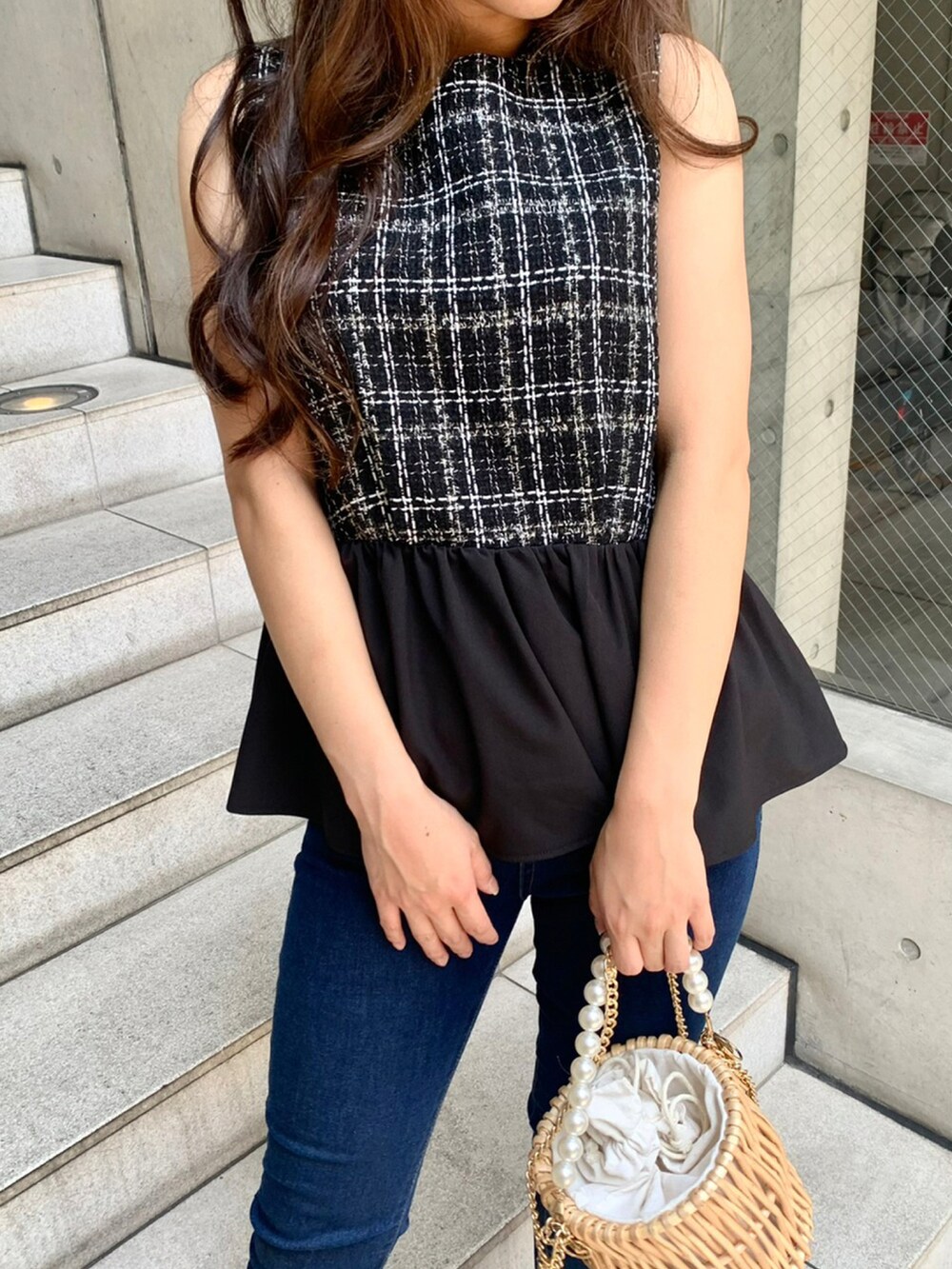 ブラック系のTシャツ/カットソー、ブルー系のデニムパンツ、ベージュ系のかごバッグを着用したレディースの夏コーディネートの3枚目の写真