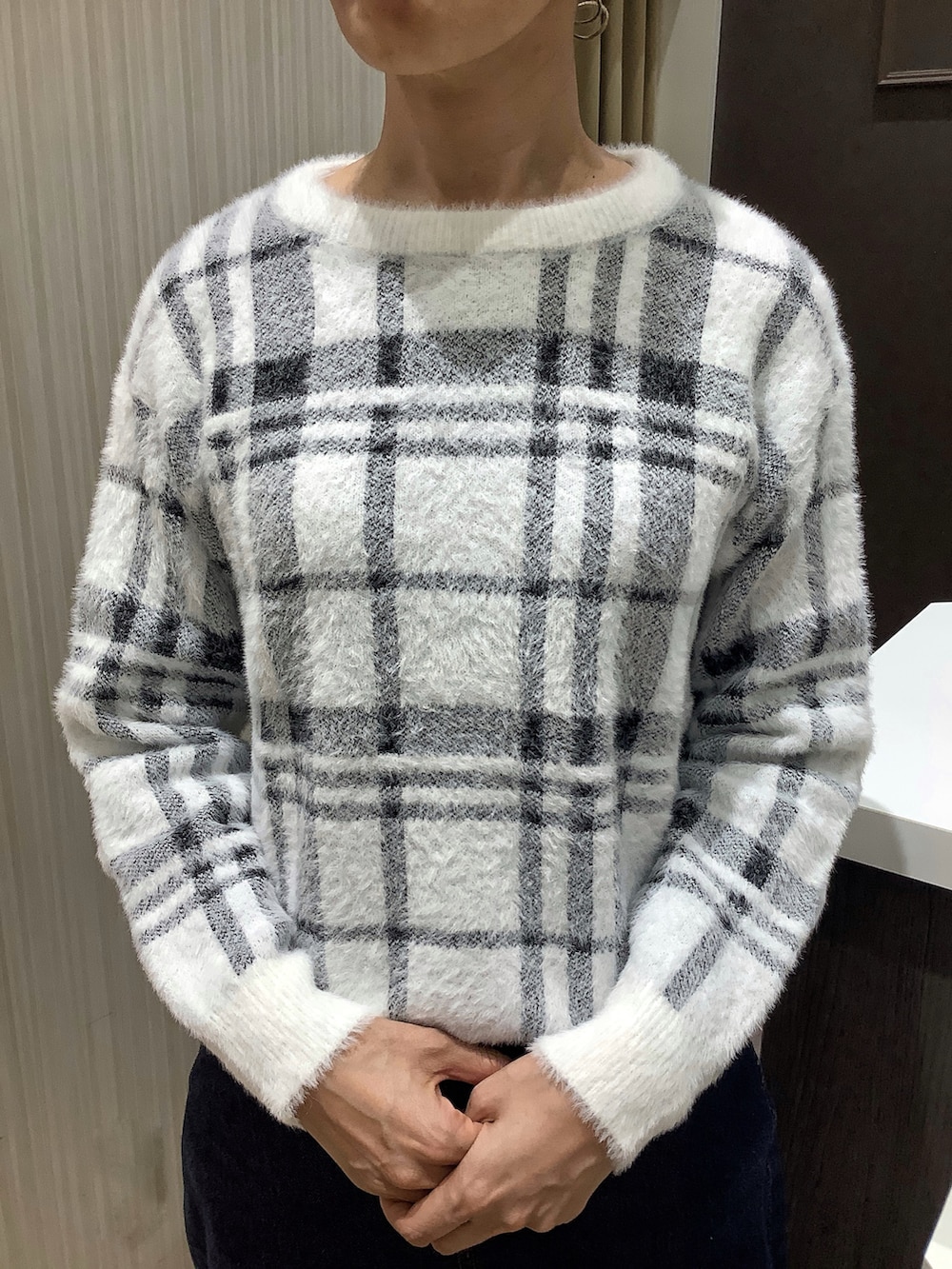 ホワイト系のニット/セーターを着用したレディースの冬コーディネートの2枚目の写真