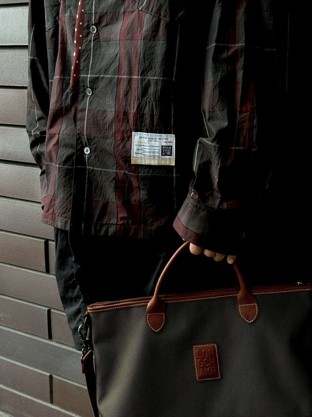 ブラウン系のローファー、ブラック系のその他パンツ、ブラウン系のビジネスバッグを着用したメンズの冬コーディネートの2枚目の写真