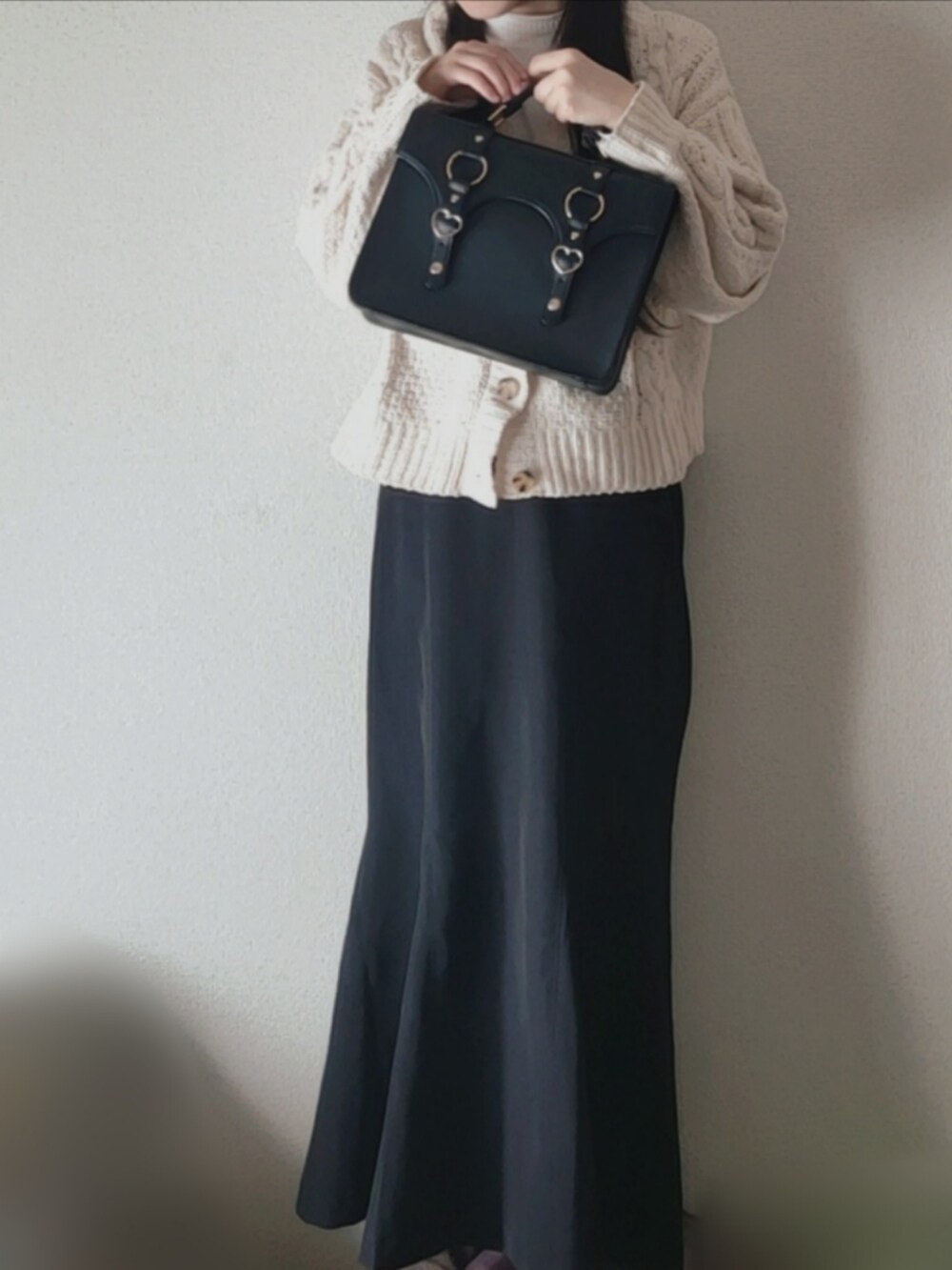 ブラック系のスカート、ホワイト系のニット/セーターを着用したレディースの冬コーディネートの2枚目の写真