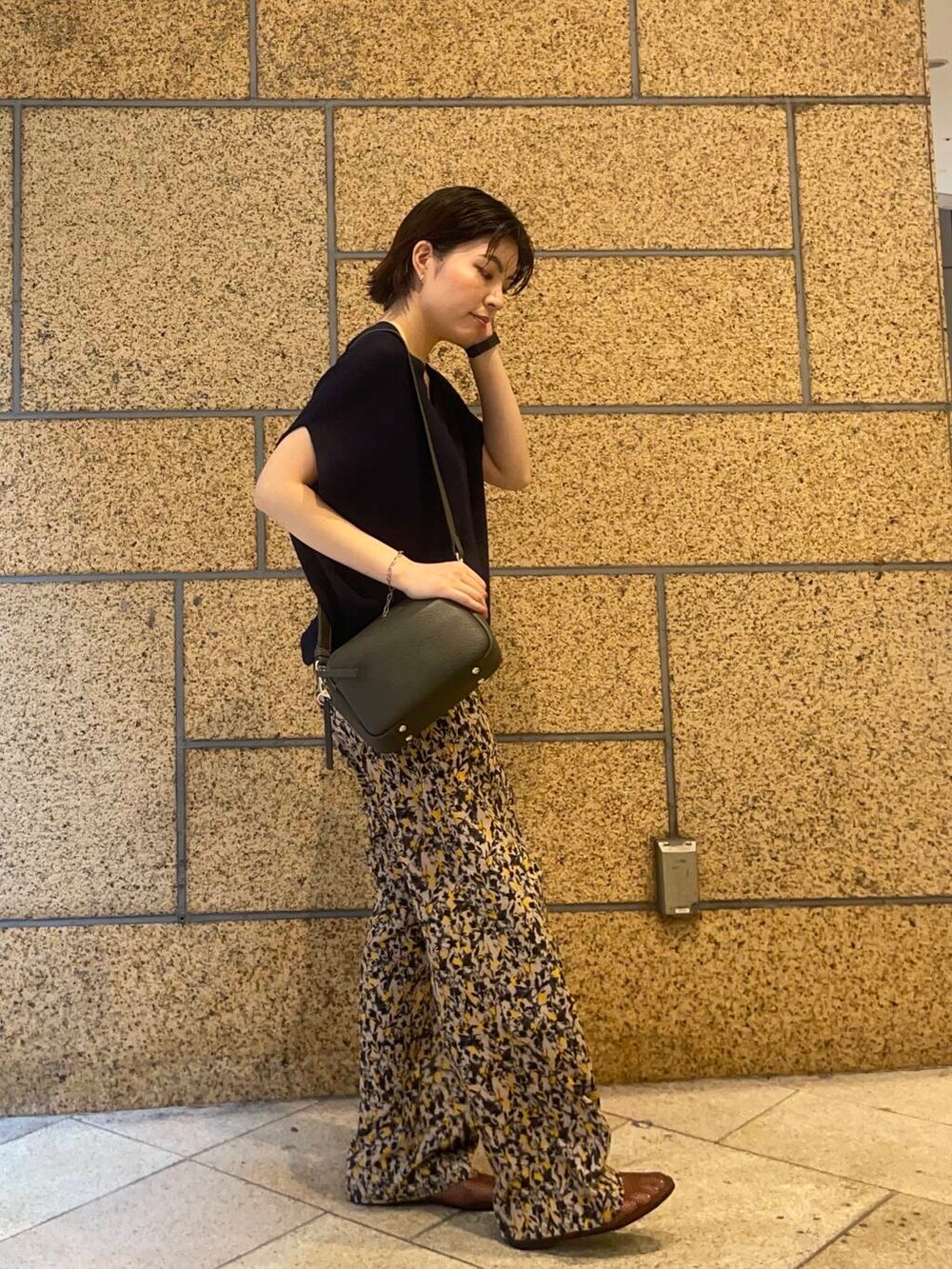 グリーン系のショルダーバッグ、ブラウン系のバレエシューズ、ベージュ系のその他パンツを着用したレディースの夏コーディネートの2枚目の写真