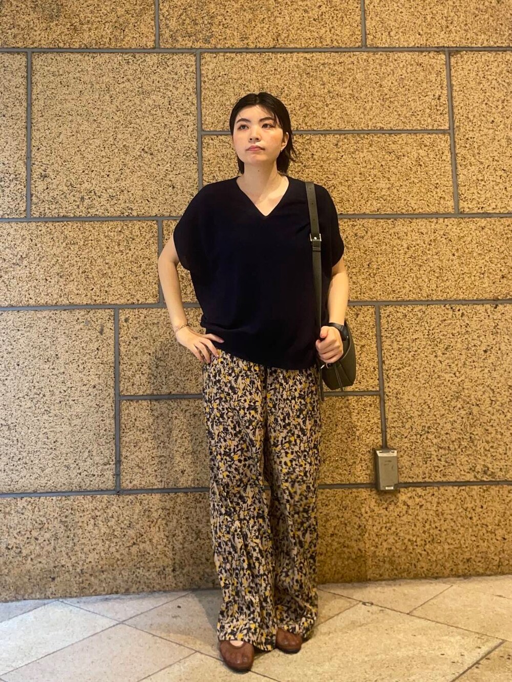 グリーン系のショルダーバッグ、ブラウン系のバレエシューズ、ベージュ系のその他パンツを着用したレディースの夏コーディネートの3枚目の写真