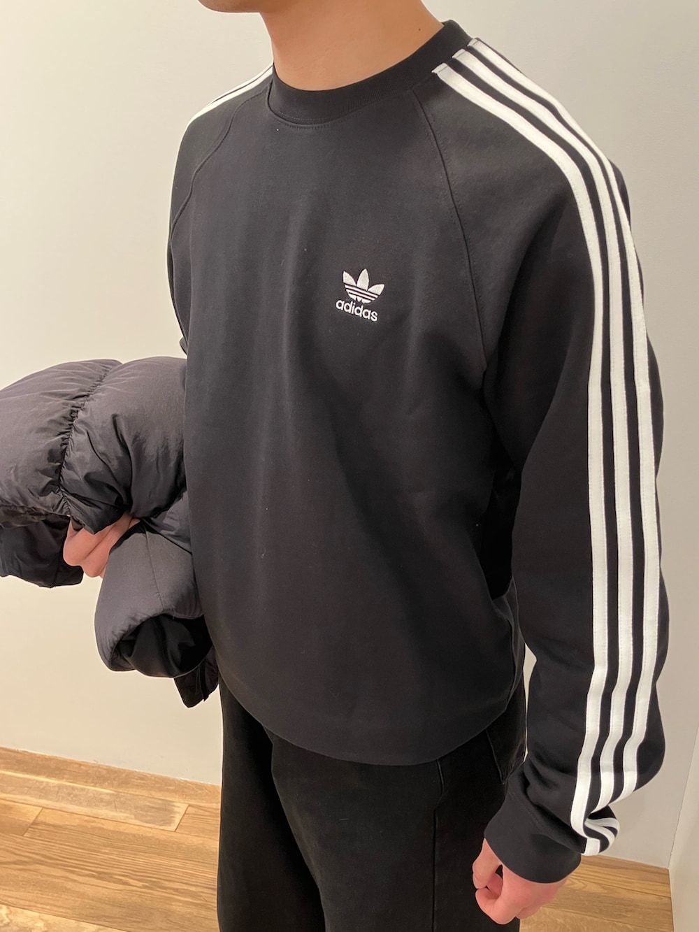 ブラック系のジャケット/アウター、ブラック系のスウェット、イエロー系のスニーカーを着用したメンズの冬コーディネートの3枚目の写真