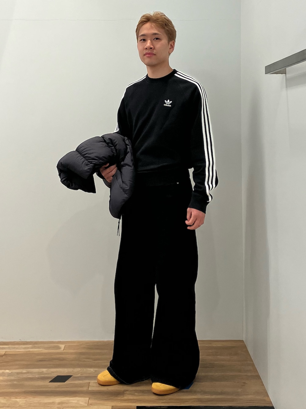 ブラック系のジャケット/アウター、ブラック系のスウェット、イエロー系のスニーカーを着用したメンズの冬コーディネートの2枚目の写真