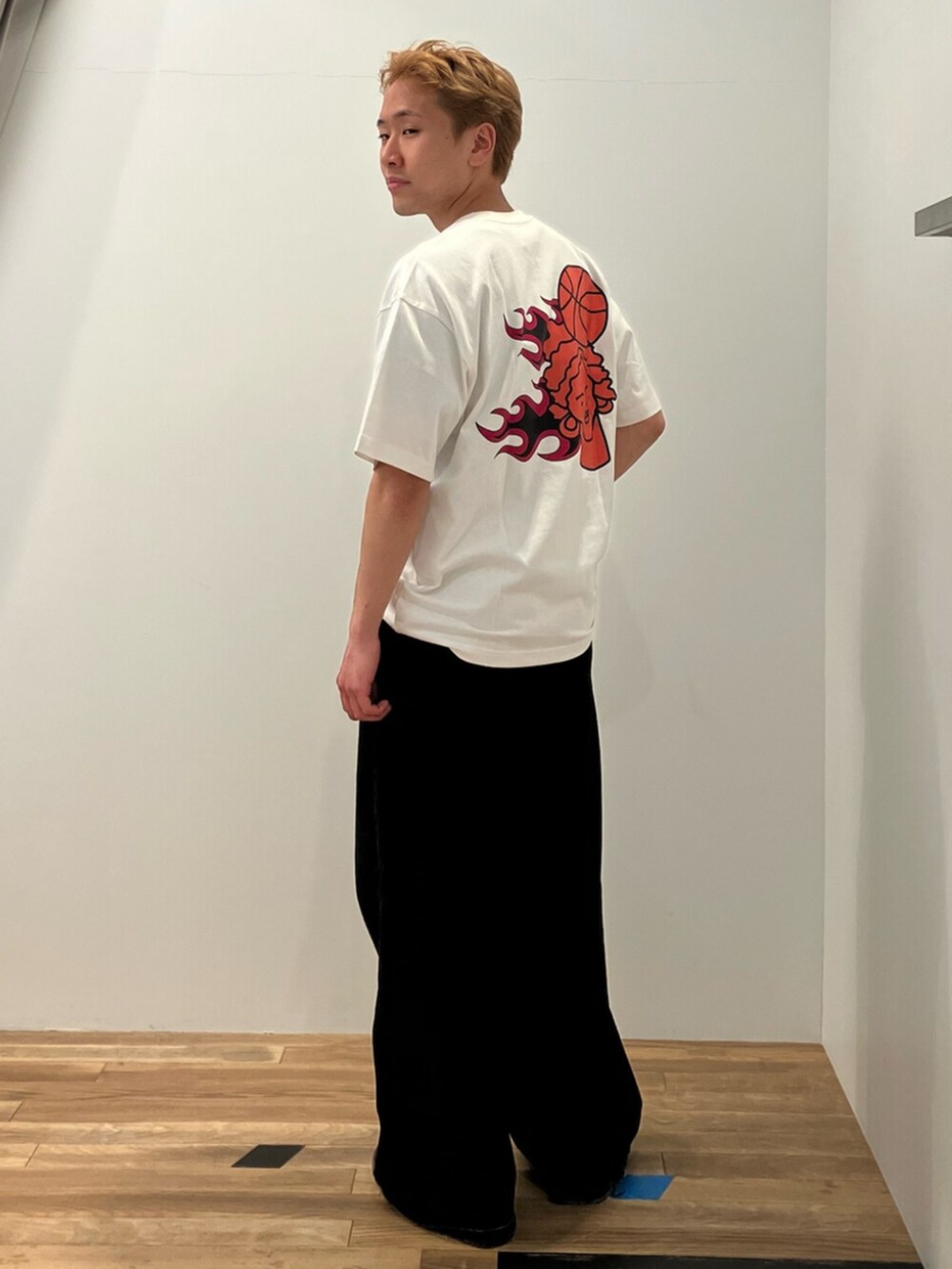 ブラウン系のパーカー、ホワイト系のトップス、ブラウン系のスニーカーを着用したメンズの冬コーディネートの2枚目の写真