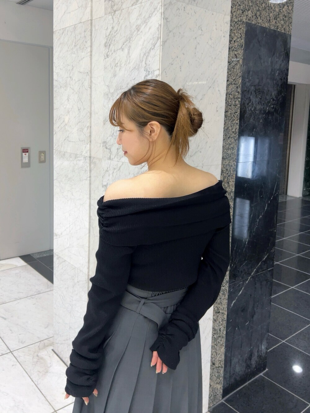 ブラック系のニット/セーター、グレー系のスカート、ブラウン系のブーツを着用したレディースの秋コーディネートの5枚目の写真