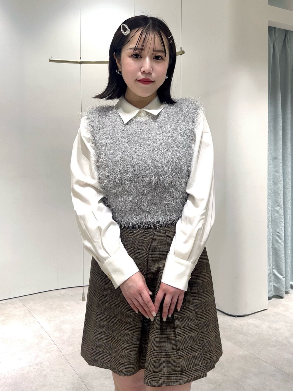 グレー系のニット/セーター、ホワイト系のシャツ/ブラウス、ブラウン系のスカートを着用したレディースの秋コーディネートの5枚目の写真