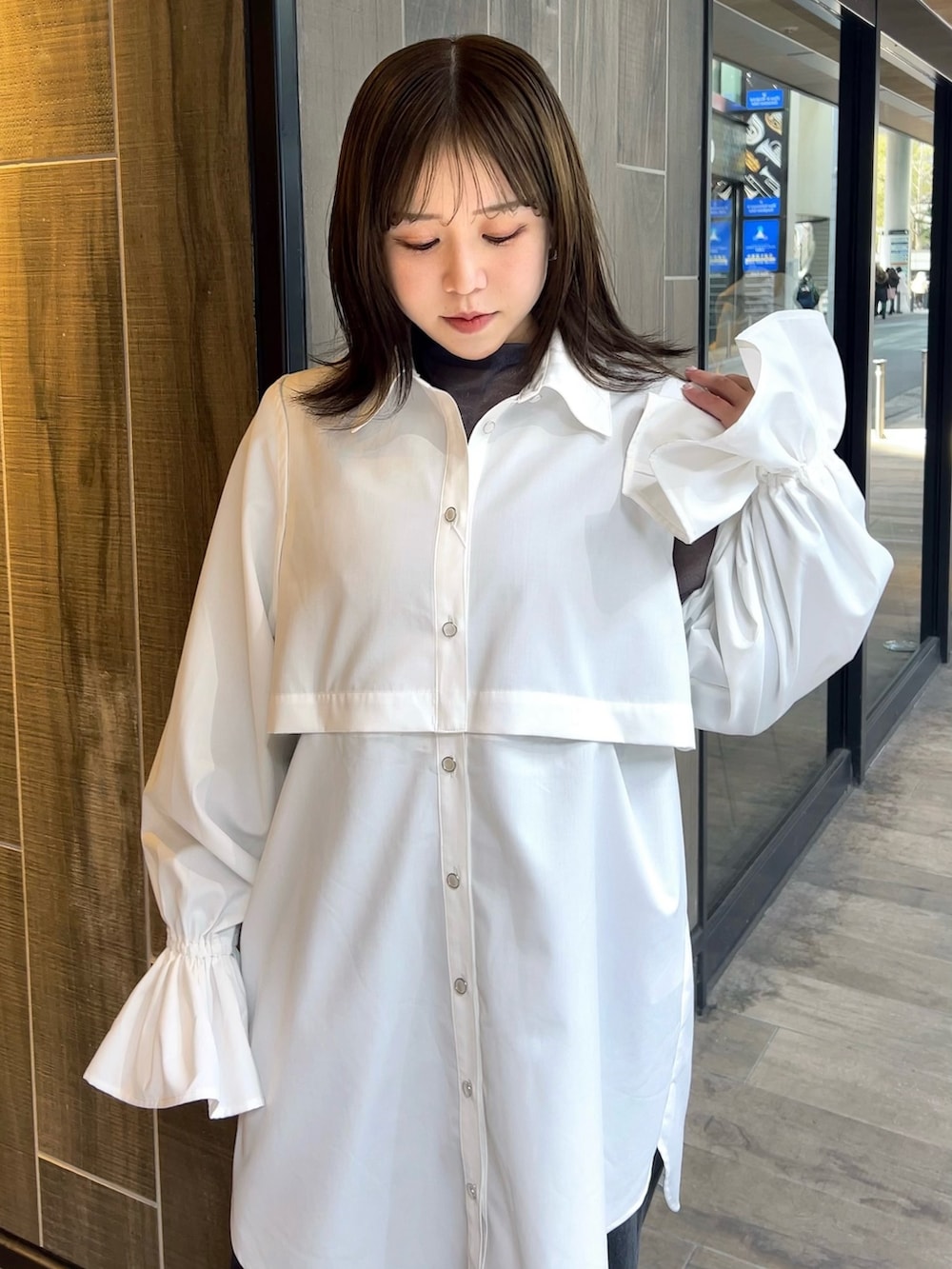 ホワイト系のワンピース、ブラック系のデニムパンツ、ブラック系のブーツを着用したレディースの春コーディネートの3枚目の写真