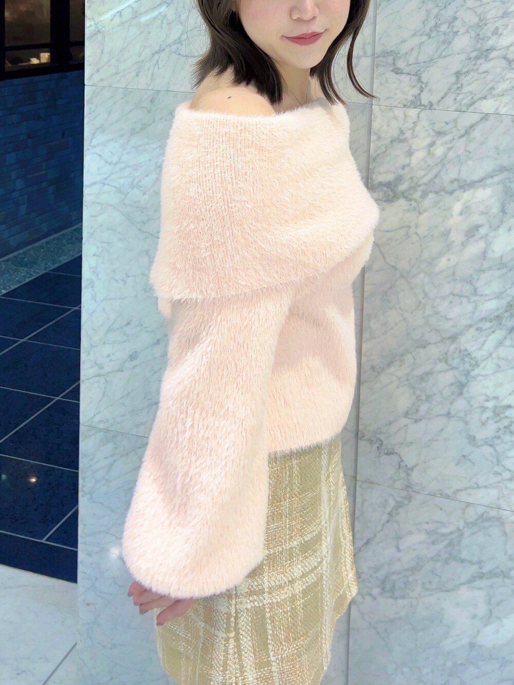 ピンク系のニット/セーター、ベージュ系のスカート、ベージュ系のブーツを着用したレディースの冬コーディネートの7枚目の写真