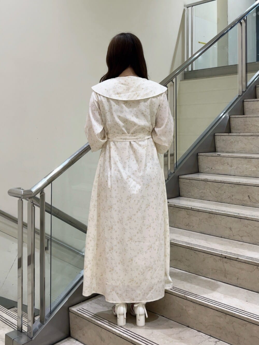 イエロー系のワンピース、イエロー系のハンドバッグ、ホワイト系のパンプスを着用したレディースの秋コーディネートの4枚目の写真