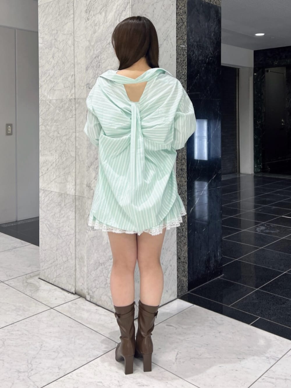 グリーン系のシャツ/ブラウス、グリーン系のスカート、ブラウン系のブーツを着用したレディースの春コーディネートの4枚目の写真