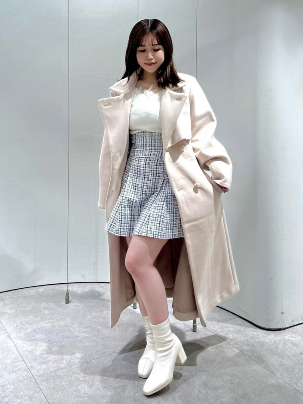 ホワイト系のブーツ、その他のスカート、ピンク系のトレンチコートを着用したレディースの秋コーディネートの3枚目の写真