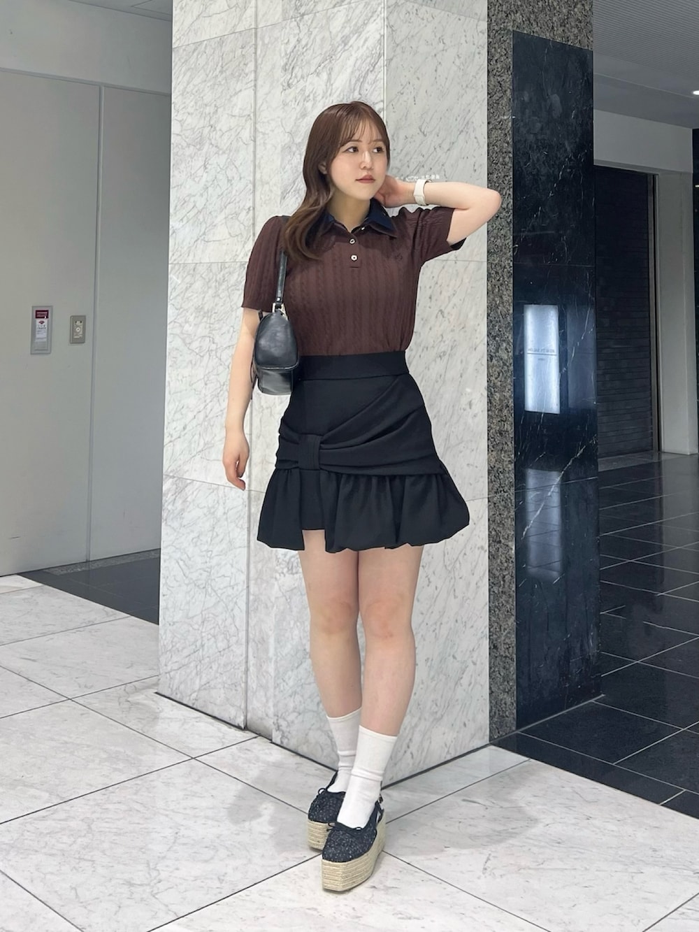 ブラウン系のニット/セーター、ブラック系のスカート、ブラック系のサンダルを着用したレディースの夏コーディネートの2枚目の写真